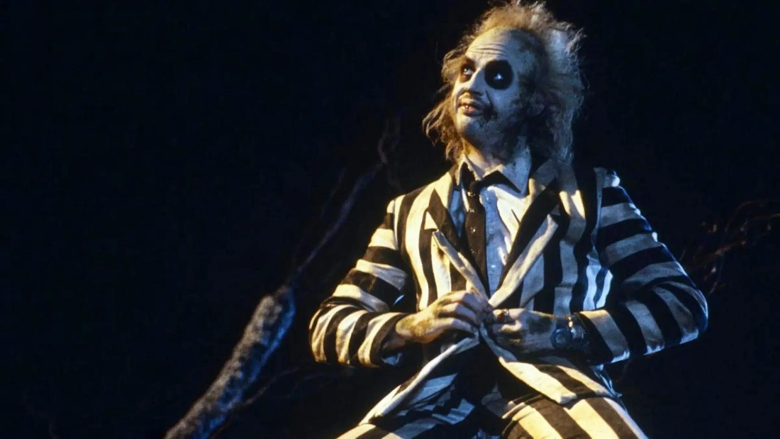 Beetlejuice: La locura de lo macabro hecha diversión. "Beetlejuice" es una explosión de imaginación que desafía las normas de lo macabro y lo convierte en una experiencia visualmente envolvente y divertidamente siniestra. Tim Burton, en su esencia más pura, nos entrega una película que juega con la muerte y lo sobrenatural de una manera que no se siente pesada ni sombría, sino electrizante y caricaturesca.